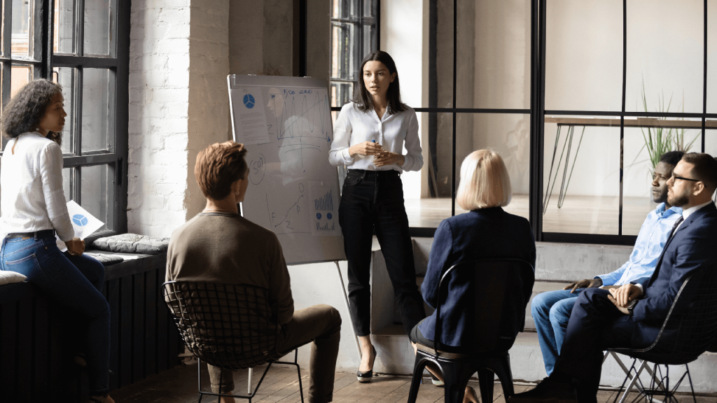 a woman coaches a team of business people